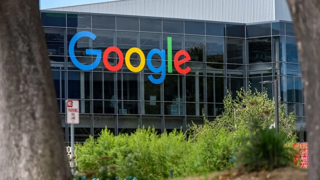 A Google sign on the exterior of a glass office building.