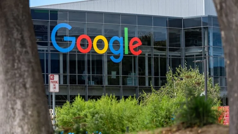 A Google sign on the exterior of a glass office building.
